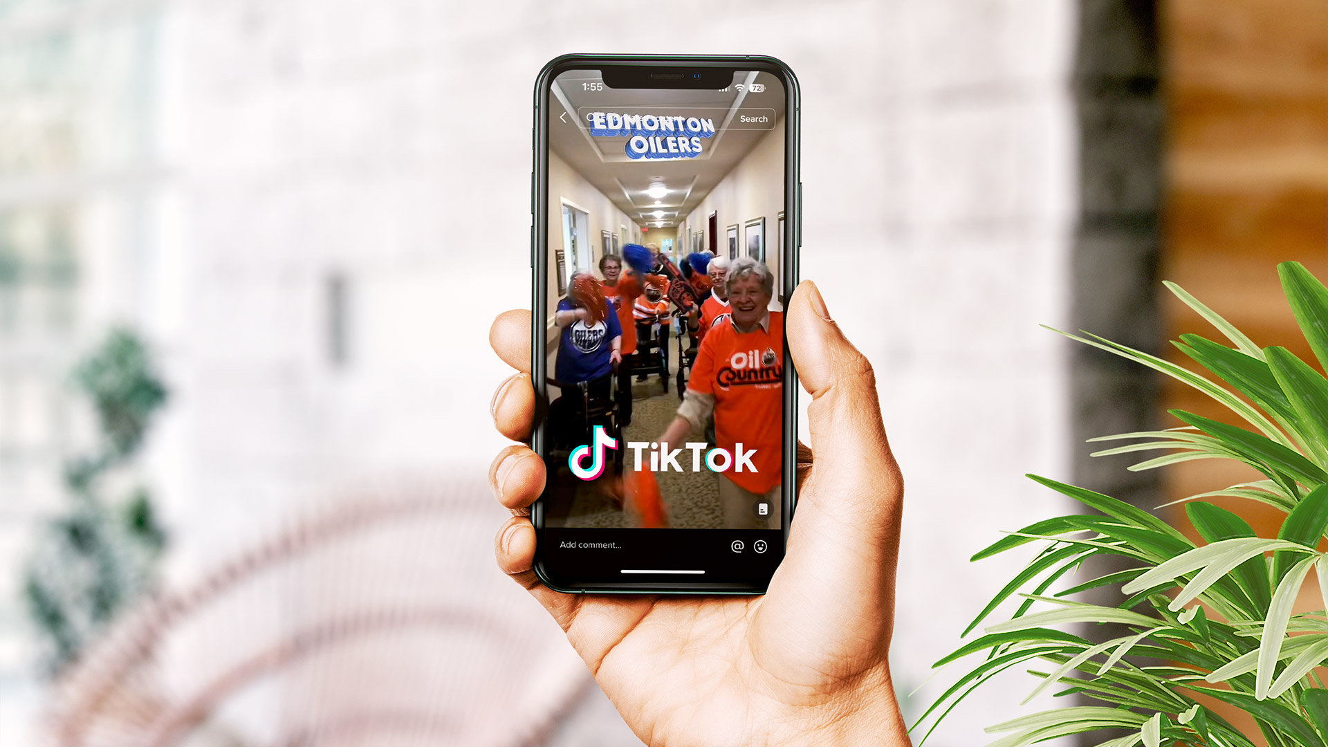 A person holding a phone showing a TikTok video of seniors cheering the Oilers